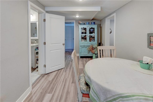 dining space featuring light wood-style flooring and baseboards