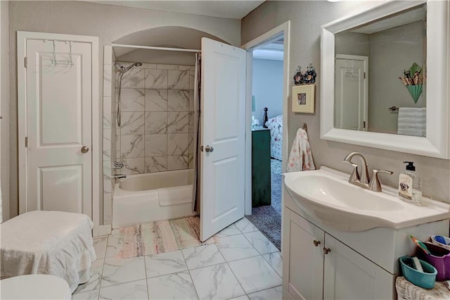 full bath featuring marble finish floors, vanity, and shower / bath combination