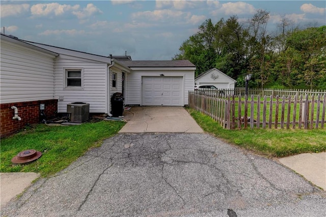 garage with driveway and central AC unit