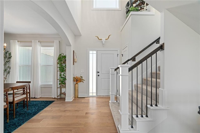 18873 W 168th Ter, Olathe, KS 66062 - foyer entrance with arched walkways, light wood finished floors, stairway, and baseboards