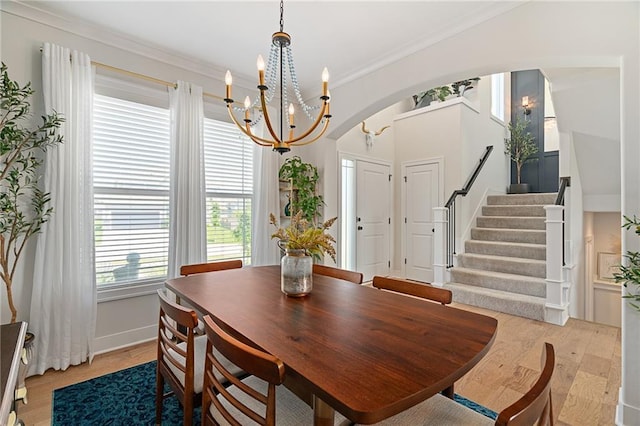 18873 W 168th Ter, Olathe, KS 66062 - dining area featuring a chandelier, stairs, arched walkways, crown molding, and baseboards