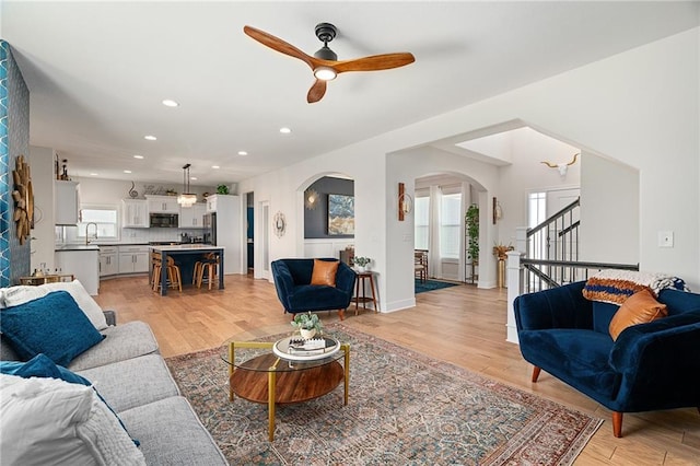 18873 W 168th Ter, Olathe, KS 66062 - living room featuring healthy amount of natural light, arched walkways, light wood-style floors, ceiling fan, and recessed lighting