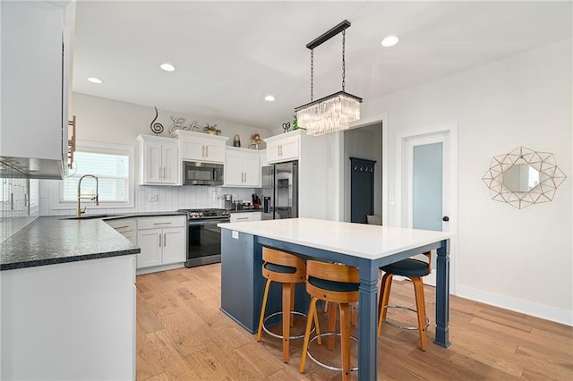 18873 W 168th Ter, Olathe, KS 66062 - kitchen with appliances with stainless steel finishes, a sink, a chandelier, light wood finished floors, and recessed lighting