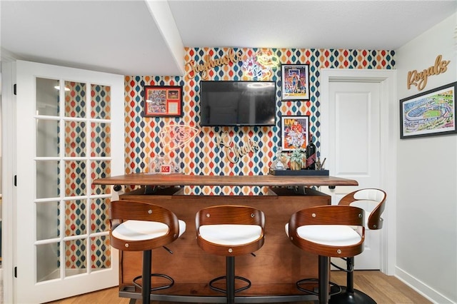 18873 W 168th Ter, Olathe, KS 66062 - bar area featuring wallpapered walls, wood finished floors, and baseboards
