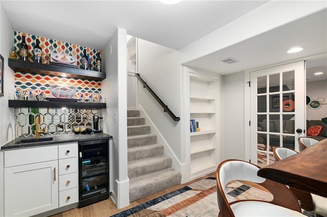 18873 W 168th Ter, Olathe, KS 66062 - indoor wet bar featuring beverage cooler, light wood-style floors, stairway, recessed lighting, and built in features