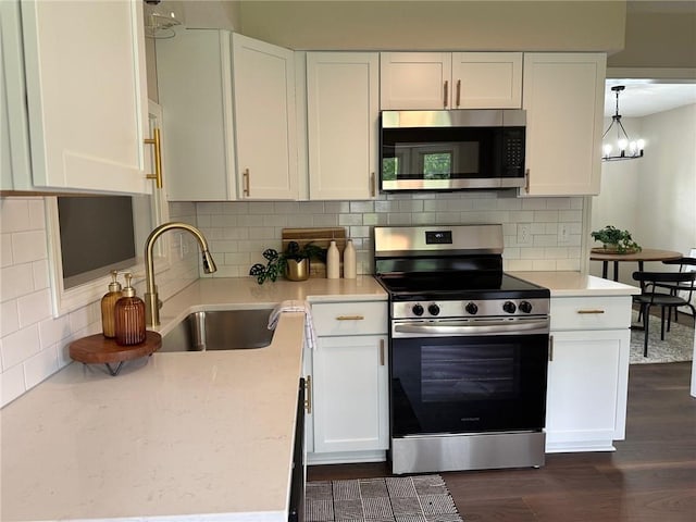 kitchen with stainless steel appliances, a sink, white cabinets, and dark wood-type flooring