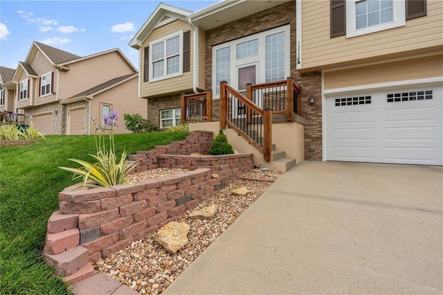 view of front of property with brick siding, a garage, driveway, and a front yard