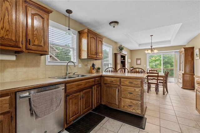 kitchen with stainless steel dishwasher, a sink, brown cabinets, decorative backsplash, and light tile patterned floors