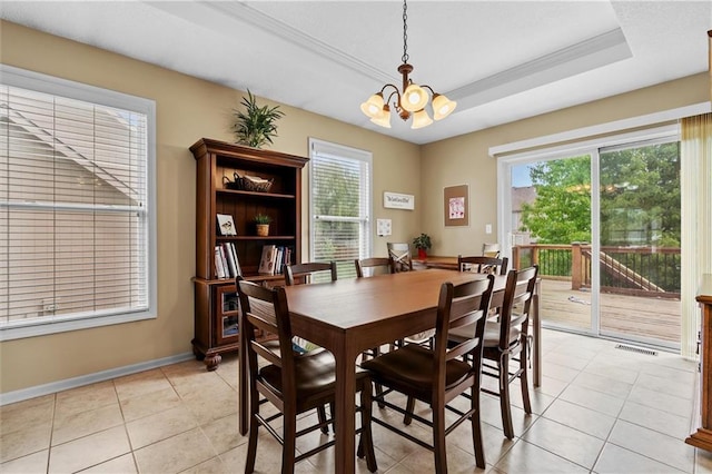 dining room with a chandelier, light tile patterned floors, baseboards, and a raised ceiling