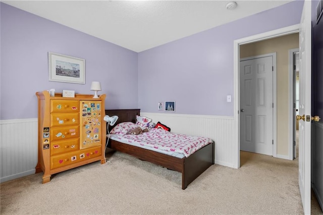 bedroom with wainscoting and carpet