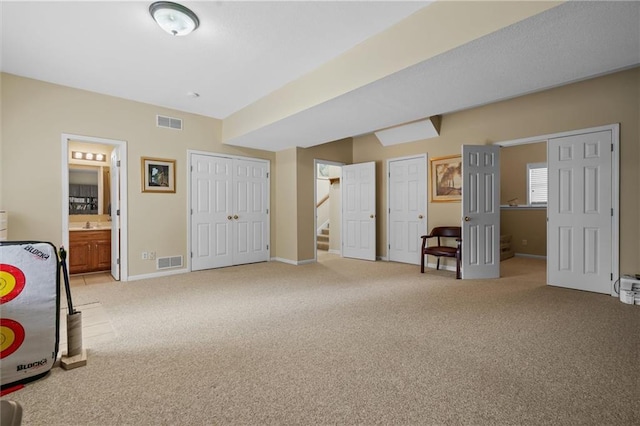 bedroom with light carpet, baseboards, and ensuite bathroom