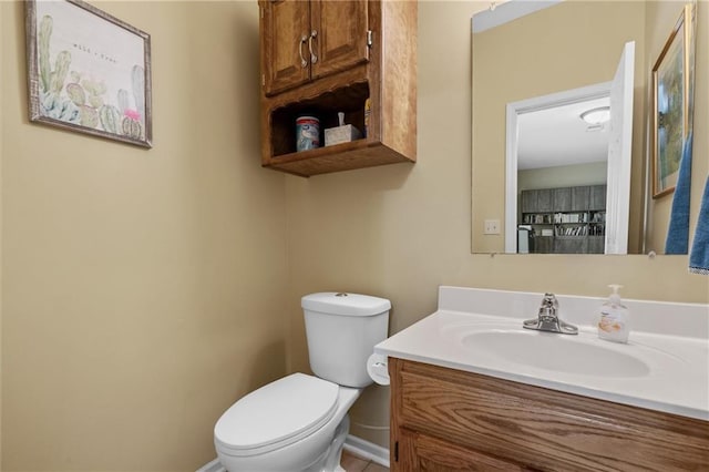 bathroom with baseboards, toilet, and vanity