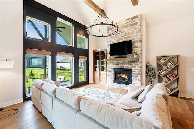1309 NW 107th Ter, Kansas City, MO 64155 - living room featuring a chandelier, light wood-style flooring, baseboards, and high vaulted ceiling