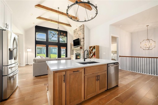 1309 NW 107th Ter, Kansas City, MO 64155 - kitchen featuring a chandelier, stainless steel appliances, a sink, open floor plan, and light wood-type flooring