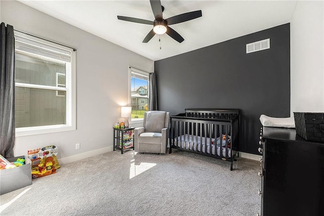 1309 NW 107th Ter, Kansas City, MO 64155 - carpeted bedroom featuring a crib, baseboards, and a ceiling fan