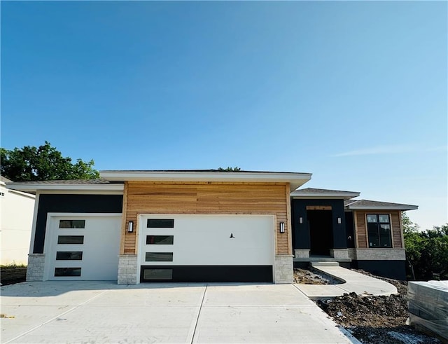 202 E Maple St, Lone Jack, MO 64070 - contemporary home featuring an attached garage, stone siding, and driveway