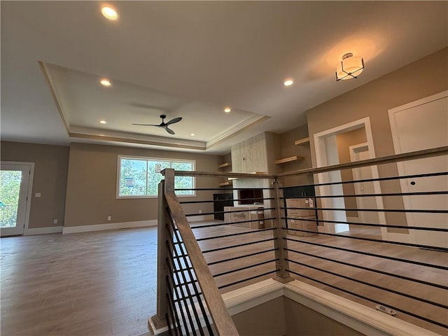 202 E Maple St, Lone Jack, MO 64070 - hall featuring a raised ceiling, plenty of natural light, wood finished floors, an upstairs landing, and recessed lighting