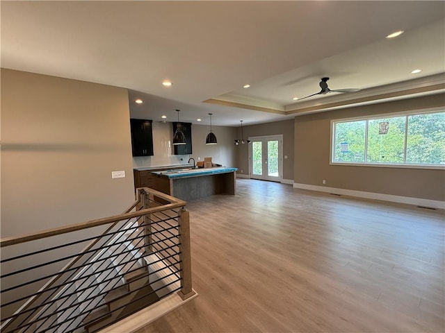 202 E Maple St, Lone Jack, MO 64070 - unfurnished living room with light wood-style floors, a raised ceiling, ceiling fan, recessed lighting, and french doors