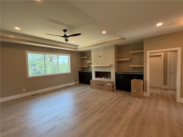 202 E Maple St, Lone Jack, MO 64070 - unfurnished living room with a tray ceiling, a ceiling fan, a large fireplace, light wood-style flooring, and recessed lighting