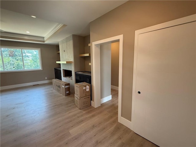 202 E Maple St, Lone Jack, MO 64070 - unfurnished living room featuring light wood-type flooring, a raised ceiling, a large fireplace, and recessed lighting