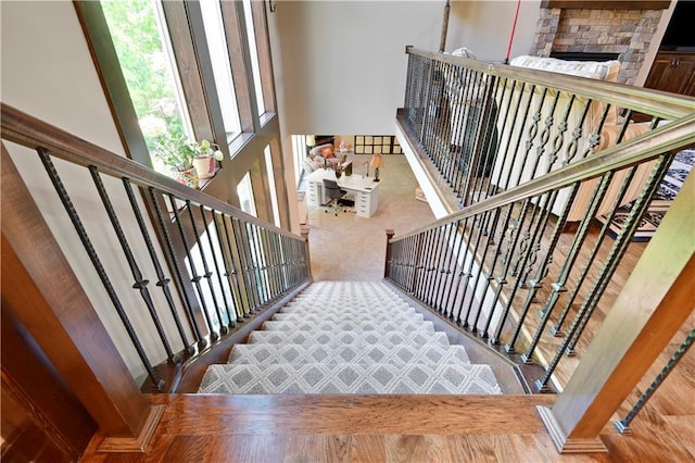 stairs with carpet and a fireplace