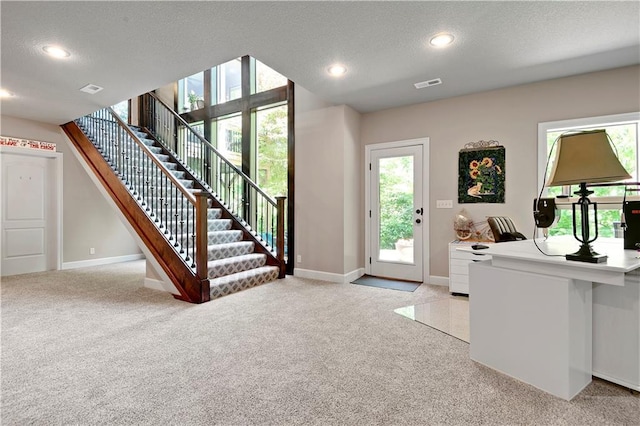 entrance foyer featuring light colored carpet, baseboards, stairway, recessed lighting, and a textured ceiling