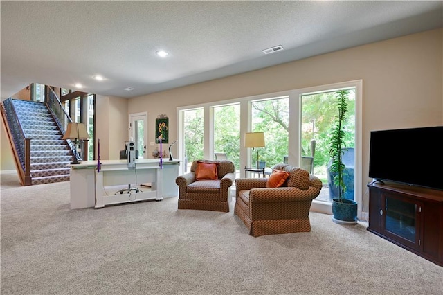 living area with carpet flooring, stairs, a textured ceiling, and recessed lighting