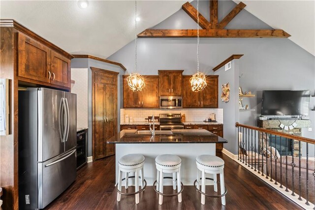31560 W 85th St, De Soto, KS 66018 - kitchen with appliances with stainless steel finishes, dark stone countertops, decorative backsplash, a breakfast bar, and dark wood-style flooring