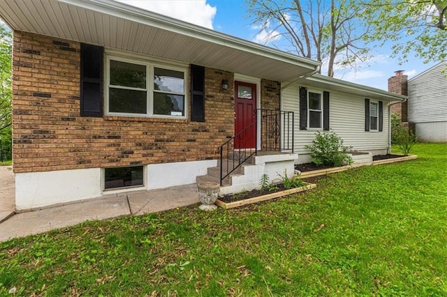 view of front of home with a front yard and brick siding