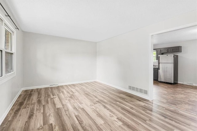 spare room with light wood finished floors and baseboards