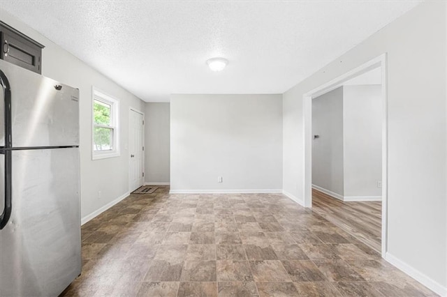 unfurnished room featuring baseboards and a textured ceiling