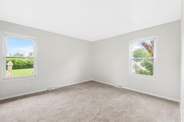spare room featuring carpet floors and baseboards