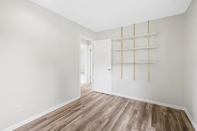 unfurnished room featuring wood finished floors and baseboards