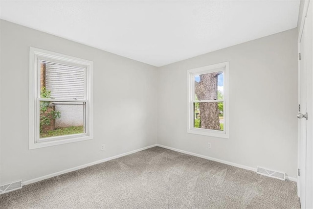 carpeted spare room featuring baseboards