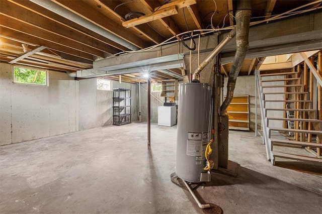below grade area with water heater, stairs, and washer / dryer