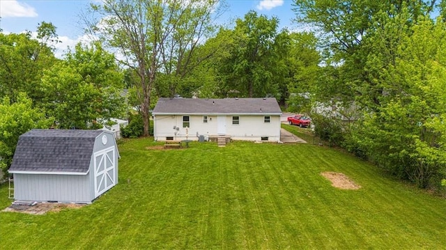 rear view of house featuring an outdoor structure, a lawn, a storage unit, and a gambrel roof