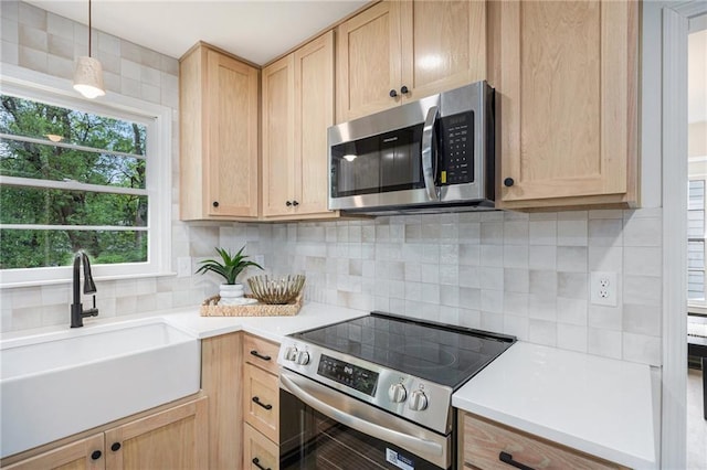 1912 E 153rd Ter, Olathe, KS 66062 - kitchen with appliances with stainless steel finishes, light brown cabinets, a sink, and light countertops