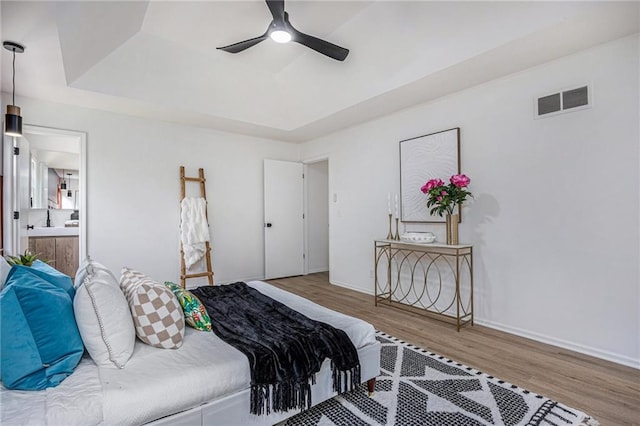 1912 E 153rd Ter, Olathe, KS 66062 - bedroom featuring wood finished floors, a raised ceiling, a ceiling fan, ensuite bath, and baseboards