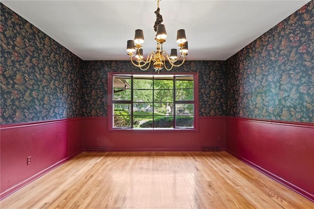 5811 W 85th Ter, Overland Park, KS 66207 - unfurnished room with a wainscoted wall, wood finished floors, a chandelier, and wallpapered walls