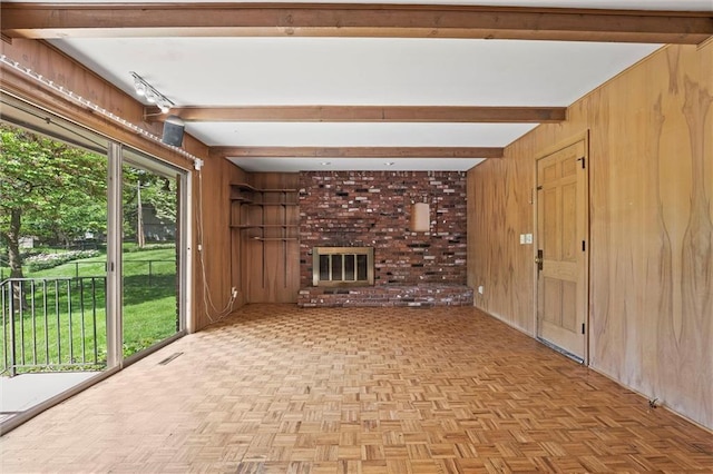 5811 W 85th Ter, Overland Park, KS 66207 - unfurnished living room with wood walls, beamed ceiling, and a brick fireplace