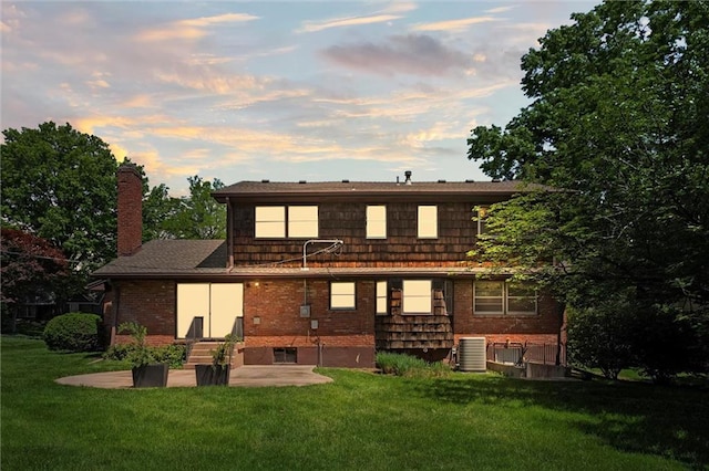 5811 W 85th Ter, Overland Park, KS 66207 - back of house featuring a chimney, central air condition unit, a lawn, brick siding, and a patio area