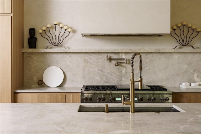 kitchen view of tasteful backsplash, pot filler, and light stone counters