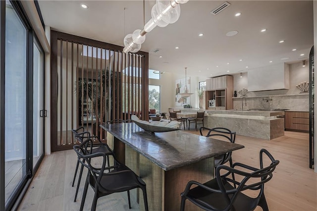 dining room with light wood finished floors and recessed lighting