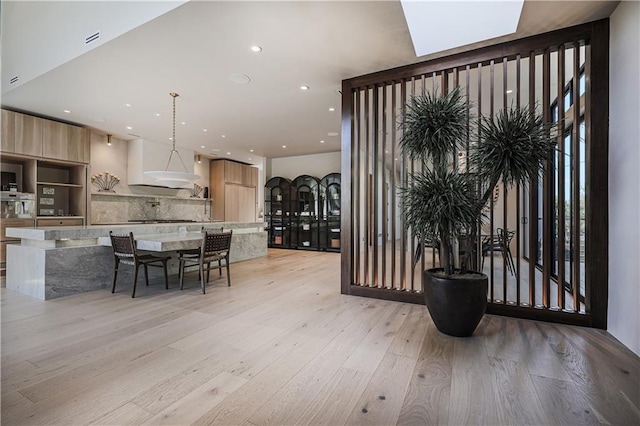 dining room with light wood-type flooring, recessed lighting, and a skylight