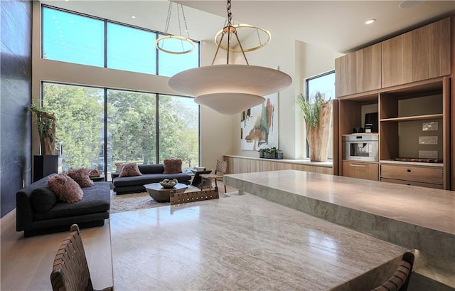 living area featuring a towering ceiling, wood finished floors, and recessed lighting