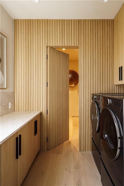 laundry area with washing machine and clothes dryer, light wood finished floors, and recessed lighting