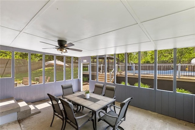sunroom with outdoor dining space, a ceiling fan, and plenty of natural light