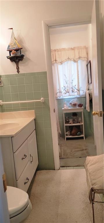 4006 W 63rd St, Prairie Village, KS 66208 - half bathroom featuring tile walls, vanity, toilet, and a wainscoted wall