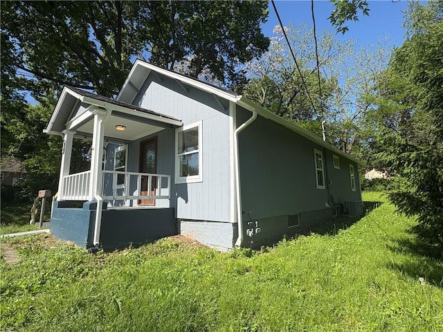 710 N Willis Ave, Independence, MO 64050 - view of side of property featuring a porch, a lawn, and cooling unit