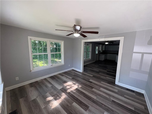 710 N Willis Ave, Independence, MO 64050 - spare room featuring ceiling fan, baseboards, and dark wood-style flooring